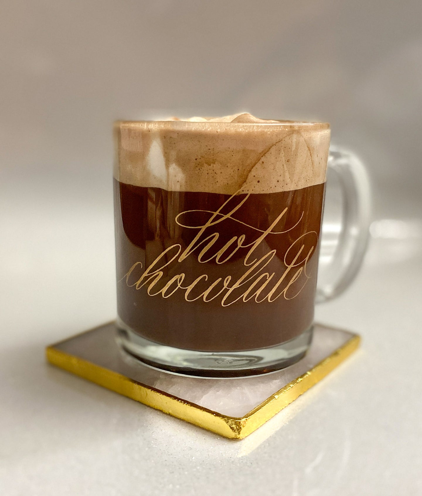 Gold hot chocolate calligraphy glass mug on a pink and gold coaster